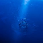 Calm blue circular waves expanding on dark background